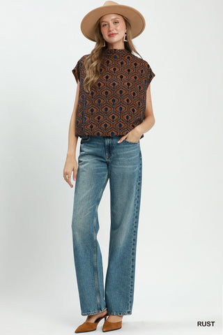 Rust brown velvet mock neck cap sleeve top with navy blue geometric peacock print pattern.