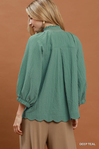 Deep teal scallop hem blouse with balloon sleeves, ruffled neckline, and textured fabric, back view.