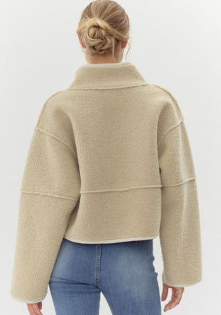 Sherpa cropped jacket with high neckline, soft faux suede on the other, and finished with jumbo snap buttons, and seam allowance out-line detailing.