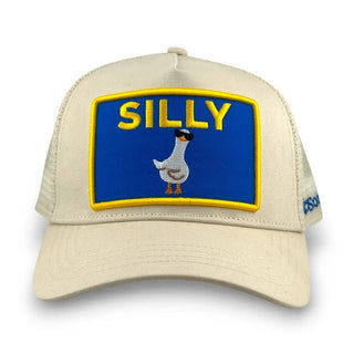 Cream trucker hat with blue and yellow embroidered patch featuring "SILLY" text and goose graphic.