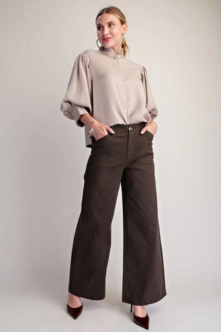 Dark brown wide-leg pants with seam stitching detail, high waist, and gold button closure.