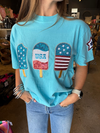 Aqua blue t-shirt with three sequined patriotic popsicle patches in red, white, and blue, featuring stars and "USA"