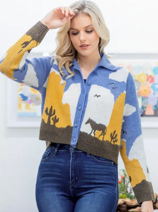 Cropped button-front knit cardigan featuring western desert scene with horse, cacti, blue sky, mustard yellow accents.