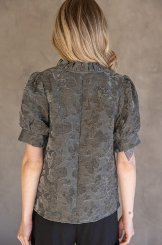 Olive green floral burnout top with puffed short sleeves, ruffled neckline, and center back seam.