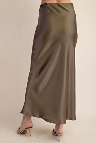 Olive green satin midi skirt with elastic waistband, bias-cut silhouette, worn with nude kitten heels.
