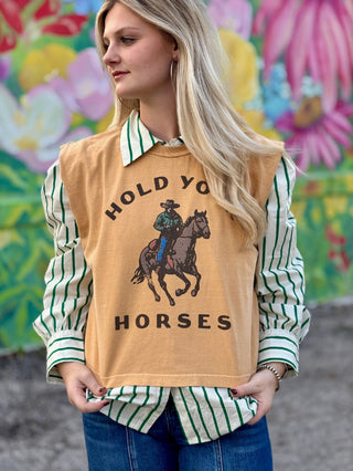 Mustard yellow boxy tank top with "Hold Your Horses" cowboy graphic, layered over green striped shirt.
