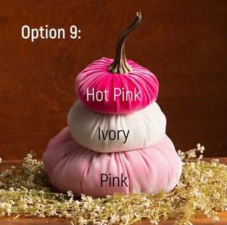 Three stacked velvet pumpkins in hot pink, ivory, and pink with a natural stem on wood surface.
