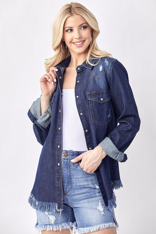 Dark wash denim shirt with frayed hem, distressed details, rolled cuffs, and snap button closure, worn open over white top.