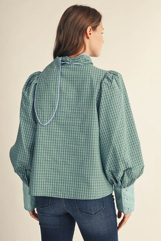 Green plaid long puff sleeve button-down shirt with blue tie neck accent, back view, paired with jeans.