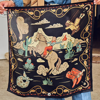 Black western bandana with cowgirl on horseback, cacti, boots, spurs, and paisley rope border design.