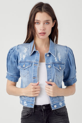 Light blue distressed crop denim jacket with puffed short sleeves, silver snap buttons, and chest pockets.