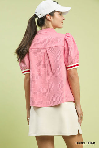 Bubble pink jacquard textured puff sleeve top with red and white striped cuffs, paired with white skirt.