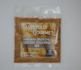 Small clear packet of Tastefully Gourmet Habanero Green Chili Cracker Seasoning Mix, showing orange-brown spice blend, 12 ser