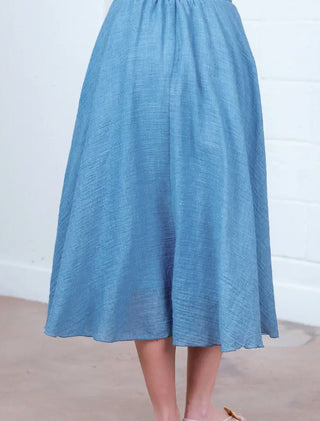 Flowy blue midi woven skirt with gathered waist, A-line silhouette, and textured linen-like fabric.