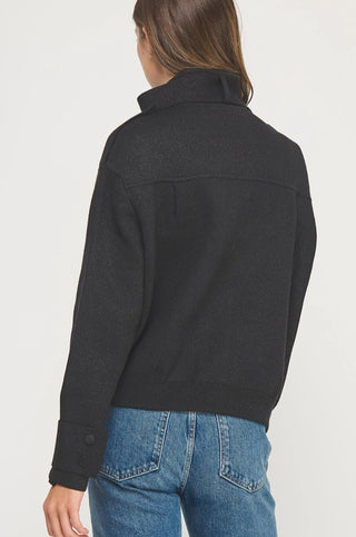 Black lurex knit jacket with satin piping details, shown from back view, paired with blue jeans.