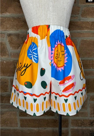 Colorful printed woven shorts featuring sun face, olives, fish, and bold abstract shapes with elastic waist.