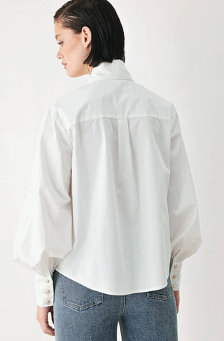 White long-sleeve button-up shirt with puffed sleeves and gold buttons, paired with blue jeans.