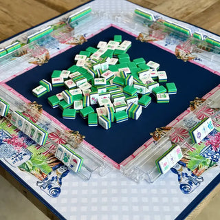 Chinoiserie Tigers mahjong mat with navy center, pink border, and green mahjong tiles stacked in middle.