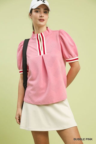 Bubble pink jacquard textured puff sleeve top with red and white striped mock neck and cuffs.