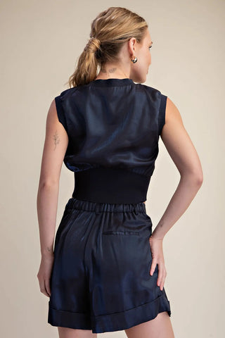 Navy blue satin sleeveless crop top with ribbed wide waistband, worn with matching satin shorts, back view.