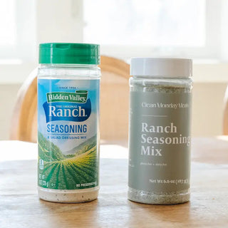 Two ranch seasoning mix containers side by side: Hidden Valley Ranch (green lid) and Clean Monday Meals (gray lid).