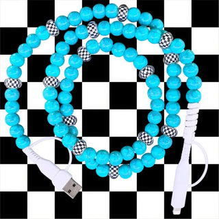 Turquoise and checkered beaded USB charging cable coiled on black and white checkered background with Lightning connector.