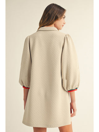 Beige textured 3/4 puff sleeve collared mini dress with red and green striped cuffs, back view.