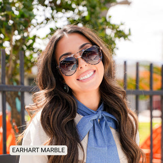 Woman wearing Earhart Marble polarized aviator sunglasses with tortoise frames and gradient lenses outdoors.