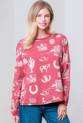 Red long sleeve sweatshirt top with white western print featuring cowboys, horseshoes, boots, and cacti.