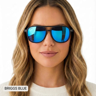 Woman wearing DAX Briggs small aviator sunglasses with black frames and blue mirrored polarized lenses.
