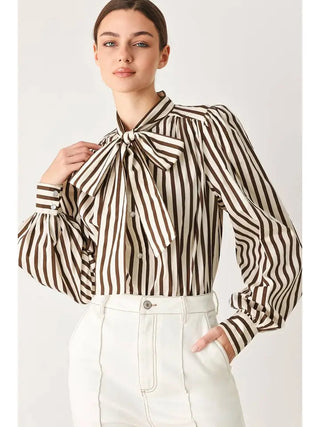 Brown and cream vertical striped woven blouse with oversized bow neckline and puffed long sleeves.