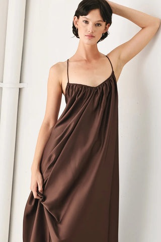 Truffle brown satin midi slip dress with thin straps, gathered neckline, and flowing silhouette.
