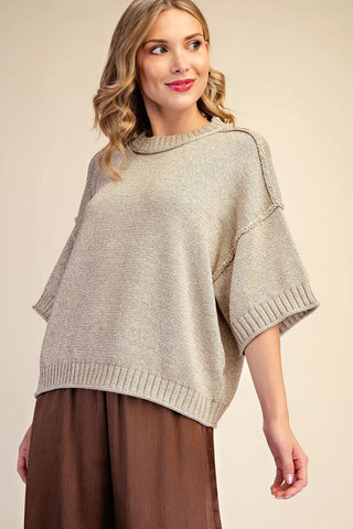 Oversized beige lurex metallic short-sleeve knit sweater with mock neck and ribbed hem detailing.
