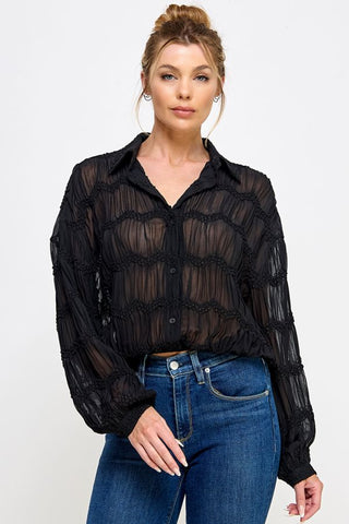 Black sheer long sleeve button-down blouse with textured smocked detailing and elastic hem waistband.