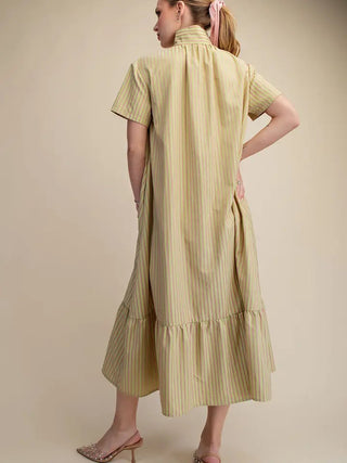 Light yellow striped midi dress with stand collar, short sleeves, ruffled hem, and relaxed fit shown from back.