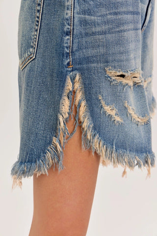 Mid waisted light wash blue denim cut off shorts with distressed rips and frayed hem detail.