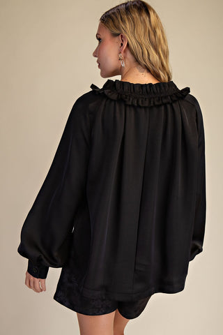 Black oversized satin blouse with ruffled round neckline and billowy long balloon sleeves, back view.