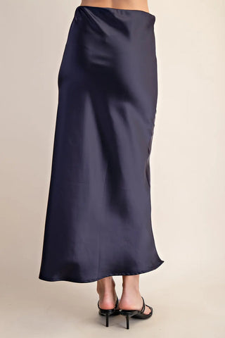 Navy blue satin midi skirt with elastic waistband, shown from back view, paired with black heels.