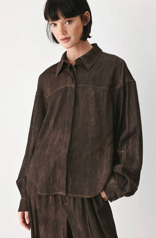 Oversized dark brown acid-washed button-down shirt with long balloon sleeves and contrast stitching details.