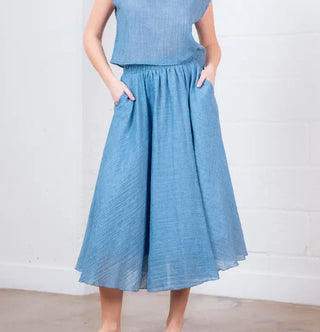 Midi blue woven skirt with gathered waistband, side pockets, and flowy A-line silhouette.