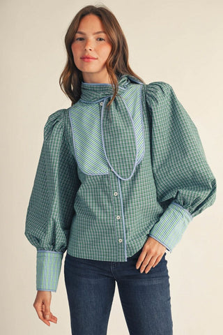 Green plaid puff sleeve button-down shirt with blue contrast tie neck accent and cuffed wrists.