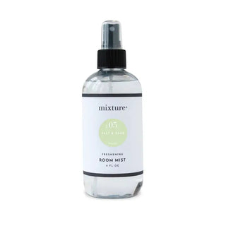 Clear glass spray bottle with black pump top, white label reading "mixture No. 05 Salt & Sage Freshening Room Mist, 8 fl oz"