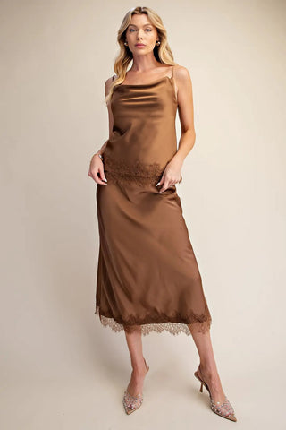 Brown satin cami top with cowl neckline, spaghetti straps, and delicate lace trim hem detail.