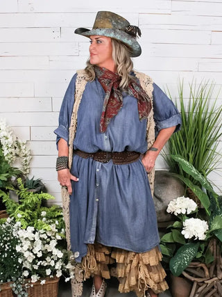 Blue chambray button-front dress with brown studded belt, worn with lace vest and floral scarf.