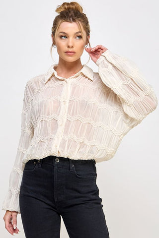 Cream sheer romantic long sleeve blouse with textured ruffle stripes, button-front, and collar neckline.