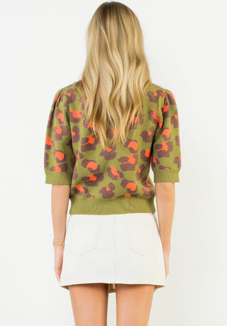 Olive green short sleeve knit top with orange and brown leopard print, featuring puff sleeves and ribbed hem.