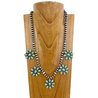 Silver Navajo pearl bead necklace featuring five green turquoise stone cluster concho pendants on wooden display bust.