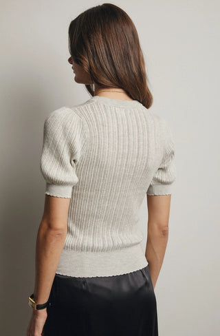 Light gray ribbed knit puff sleeve top with scalloped hem detail, shown from the back.