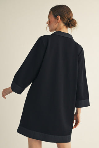Navy blue 3/4 sleeve solid shift dress with contrast trim detailing and side pockets, back view.