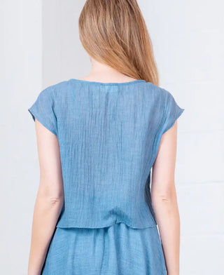 Light blue linen dolman sleeve scoop neck top with relaxed fit, shown from back view.